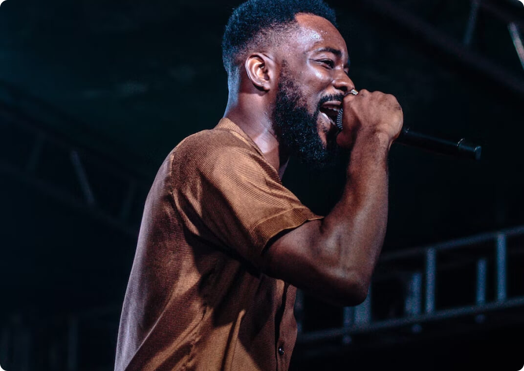 male singer on microphone in dark building