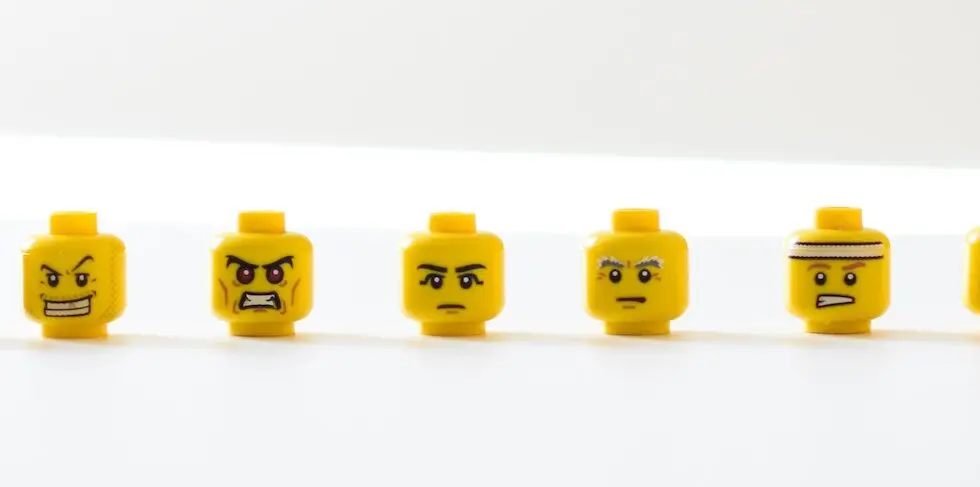 Image accompanying influencer marketing interview questions: eight LEGO minifig heads lined up on a white background. Each minifig face shows a negative emotion, from anger, to disappointment, to confusion