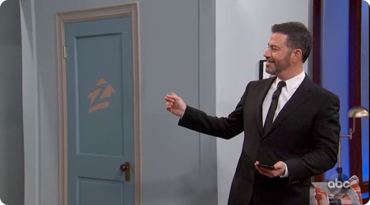 tv product integration man pointing at blue door with zillow logo