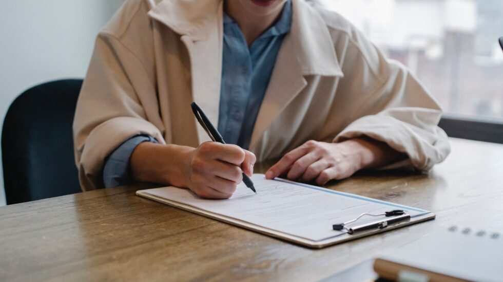 person writing on clipboard