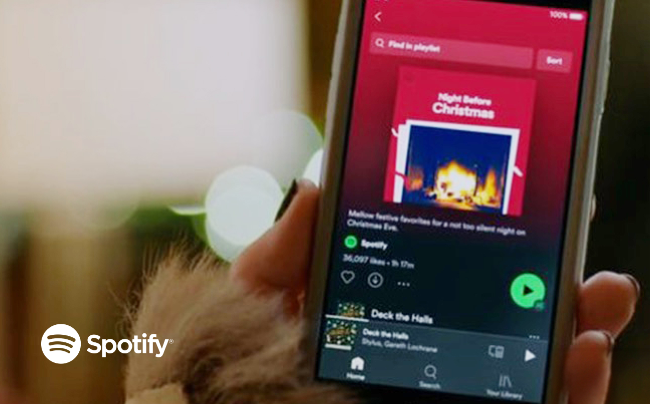 Holding a phone with Spotify interface on it