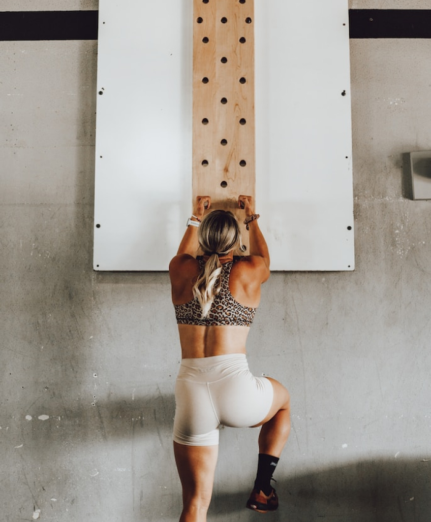 A healthy, fit woman climbing a wall