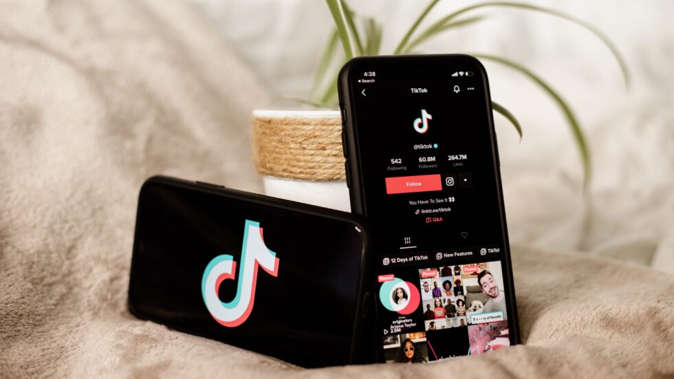 Influencer marketing for older generations: A phone displaying the TikTok logo beside another phone showing a TikTok feed