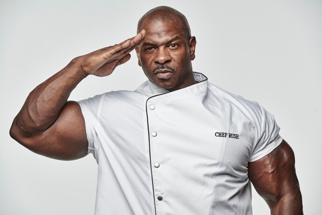 Chef Andre Rush saluting in chef's whites