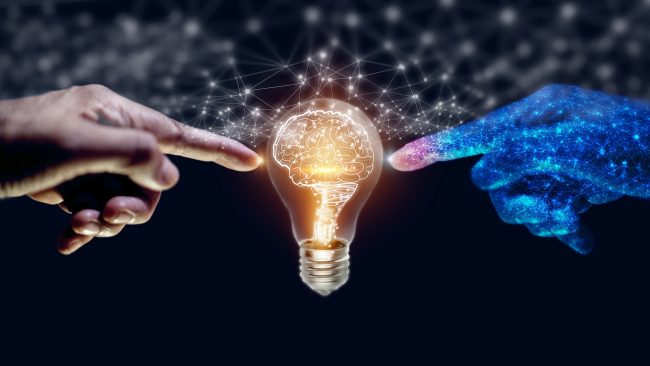 Artificial,Intelligence,(ai),Machine,Learning,,Robot,And,Human,Hands,Touching marketing AI automation: A human hand on the left, a digital hand on the right. Both touching a lightbulb with a filament that looks like a brain.